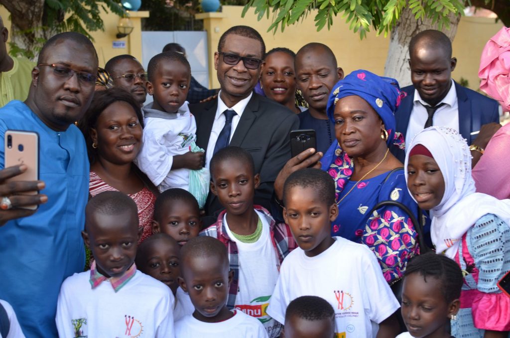 Youssou Ndour avec des hommes, des femmes et des enfants